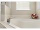 Soaking tub with modern fixtures, tile accents, and a decorative flower arrangement at 36300 Grand Island Oaks Cir, Grand Island, FL 32735