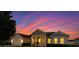 Charming single-story home with a well-manicured lawn set against a beautiful sunset sky at 36300 Grand Island Oaks Cir, Grand Island, FL 32735