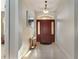 Inviting foyer featuring tile flooring, elegant lighting, and a decorative entry door at 36300 Grand Island Oaks Cir, Grand Island, FL 32735