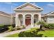 Inviting home exterior featuring arched entryway, well-kept landscaping, and a charming palm tree at 36300 Grand Island Oaks Cir, Grand Island, FL 32735