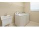 Functional laundry room with a sink, washer, dryer, and ample shelving for storage, combining utility and convenience at 36300 Grand Island Oaks Cir, Grand Island, FL 32735