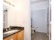 Bathroom features a vanity with granite countertop, wood-look flooring, and a toilet visible through doorway at 4011 Venetian Bay Dr # 103, Kissimmee, FL 34741