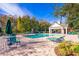 Community pool with lounge chairs and seating, next to a covered pavilion and surrounded by lush trees at 4011 Venetian Bay Dr # 103, Kissimmee, FL 34741