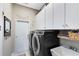 Laundry room with sleek, dark gray washer and dryer, and white cabinets for ample storage at 421 Thomez Ct, Lake Mary, FL 32746