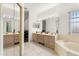 Bright bathroom features a large vanity, soaking tub, and mirrored closet doors at 4371 Vestawood Ct, Sanford, FL 32773