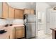 Functional kitchen featuring stainless steel appliances, natural wood cabinetry, and tile flooring at 4371 Vestawood Ct, Sanford, FL 32773
