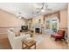 Cozy living room with a fireplace, ceiling fans, light wood floors, and a sliding glass door to the patio at 4371 Vestawood Ct, Sanford, FL 32773