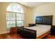 Bright bedroom with a large arched window, hardwood floors, and a comfortable bed at 4522 Weeping Willow Cir, Casselberry, FL 32707