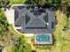 Aerial view of a home with solar panels, a screened-in pool, and lush landscaping at 5297 Mill Stream Dr, St Cloud, FL 34771