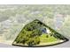 Overhead community view with verdant trees surrounding houses and a street for access at 5297 Mill Stream Dr, St Cloud, FL 34771