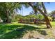Expansive backyard with mature trees, lush lawn, and a fun tree swing near the screened-in pool at 5297 Mill Stream Dr, St Cloud, FL 34771