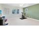 Spacious room with light green accent wall, exercise bike, and a large window with natural light at 5297 Mill Stream Dr, St Cloud, FL 34771
