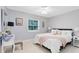 Cozy bedroom with soft gray walls, a comfortable queen bed, a ceiling fan, and natural light at 5297 Mill Stream Dr, St Cloud, FL 34771