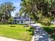 Charming two-story home featuring a long driveway, well-manicured lawn, and mature trees for added privacy at 5297 Mill Stream Dr, St Cloud, FL 34771