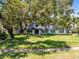 Inviting home with a brick facade, a vibrant red front door, solar panels, and a spacious front yard at 5297 Mill Stream Dr, St Cloud, FL 34771