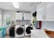 Well-equipped laundry room with modern washer and dryer, storage cabinets, and counter space at 5297 Mill Stream Dr, St Cloud, FL 34771