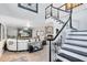 Bright open-concept living room featuring a fireplace, hardwood floors, a large sectional sofa, and access to the staircase at 5297 Mill Stream Dr, St Cloud, FL 34771