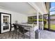 Outdoor kitchen featuring a granite countertop, sink, stainless steel grill, bar seating, and privacy screen at 5297 Mill Stream Dr, St Cloud, FL 34771