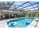 Enclosed pool featuring an outdoor kitchen, patio seating area, well-manicured landscaping, and privacy fence at 5297 Mill Stream Dr, St Cloud, FL 34771