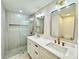 Beautiful bathroom boasts double sinks, quartz countertops, framed mirrors, and a glass walk-in shower at 560 Garden Heights Dr, Winter Garden, FL 34787