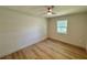 This bright bedroom features wood floors, a ceiling fan, and a large window at 560 Garden Heights Dr, Winter Garden, FL 34787