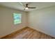 This bright bedroom features wood floors, a ceiling fan, and a large window at 560 Garden Heights Dr, Winter Garden, FL 34787