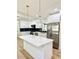 Bright renovated kitchen featuring white cabinets, stainless appliances, island, quartz countertops, and modern lighting at 560 Garden Heights Dr, Winter Garden, FL 34787
