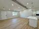Bright, open living space with wood floors leading to a modern kitchen with an island at 560 Garden Heights Dr, Winter Garden, FL 34787