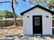 Exterior view of white storage shed with black door and sconce lighting at 560 Garden Heights Dr, Winter Garden, FL 34787
