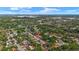 Expansive aerial shot of a neighborhood with tree-lined streets and a distant city skyline at 5612 Meridian Way, Orlando, FL 32808