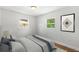 Bright bedroom with two windows and hardwood floors, adorned with a minimalist art print at 5612 Meridian Way, Orlando, FL 32808