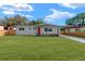 Charming single-story home boasts a vibrant red door and a lush green lawn at 5612 Meridian Way, Orlando, FL 32808