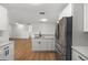 Bright, open kitchen features white cabinetry, a quartz countertop, and modern stainless steel appliances at 5612 Meridian Way, Orlando, FL 32808