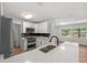 Modern kitchen with white cabinets, quartz countertop, and a stainless steel sink at 5612 Meridian Way, Orlando, FL 32808