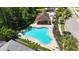 Aerial view of a vibrant blue in-ground pool with an adjacent picnic pavilion at 5815 Pine Grove Run, Oviedo, FL 32765