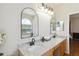 Bathroom with double sinks, granite countertops, and arched mirrors at 5815 Pine Grove Run, Oviedo, FL 32765