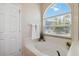 Large bathtub with a large arched window, and white tile at 5815 Pine Grove Run, Oviedo, FL 32765