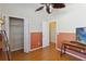 Stylish room with two-tone paint featuring a wood-look floor, fan, closet, and desk with TV at 5815 Pine Grove Run, Oviedo, FL 32765