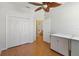 Bright bedroom with a wood-look floor features a ceiling fan, closet, and adjacent bathroom at 5815 Pine Grove Run, Oviedo, FL 32765