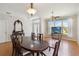 A spacious dining room featuring wood floors, a formal table, and large windows at 5815 Pine Grove Run, Oviedo, FL 32765