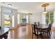A well lit dining room featuring wood floors, a formal table, and large windows at 5815 Pine Grove Run, Oviedo, FL 32765