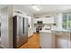 Modern kitchen with stainless steel appliances, white cabinets, and a breakfast bar at 5815 Pine Grove Run, Oviedo, FL 32765