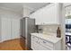 Kitchen with white cabinets, stainless steel fridge and adjacent pantry and dining area at 5815 Pine Grove Run, Oviedo, FL 32765