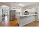 Bright kitchen featuring white cabinetry, stainless steel refrigerator, and breakfast bar at 5815 Pine Grove Run, Oviedo, FL 32765