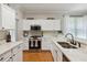 Well-lit kitchen with white cabinets, stainless steel range, and spacious countertop at 5815 Pine Grove Run, Oviedo, FL 32765