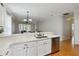 Kitchen with stainless steel dishwasher and breakfast bar overlooking dining area at 5815 Pine Grove Run, Oviedo, FL 32765