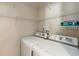 Bright laundry room with white washer and dryer and ample wire shelving for organized storage at 5815 Pine Grove Run, Oviedo, FL 32765