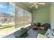 Enclosed patio featuring wicker furniture, overhead fan, and serene outdoor view through sheer blinds at 5815 Pine Grove Run, Oviedo, FL 32765