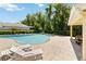 Beautiful pool area with lounge chairs on a stone patio and lush landscaping at 5815 Pine Grove Run, Oviedo, FL 32765