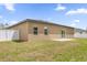 Backyard with a green lawn, partial white fence, and a patio with sliding door access to the home at 601 Marion Oaks Blvd, Ocala, FL 34473